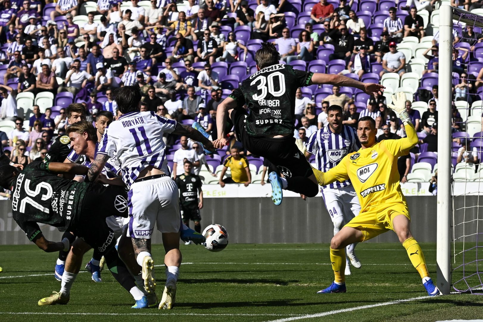 Banai Dávid, az Újpest kapusa (j), mögötte csapattársa, Patrizio Stronati (j2), középen Gruber Zsombor, a Ferencváros játékosa (j3) a labdarúgó Fizz Liga 32. fordulójában játszott Újpest FC - Ferencvárosi TC mérkőzésen a Szusza Ferenc Stadionban 2026. május 3-án.  MTI/Hegedüs Róbert